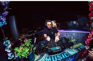 a man sitting at a table with a mixing console at Marco Polo Party Hostel in St. Julianʼs