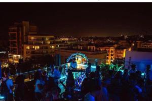 a crowd of people watching a performance at night at Marco Polo Party Hostel in St. Julianʼs