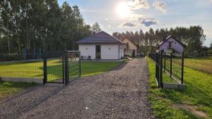una puerta en un campo con una casa en Domek Ewy en Święta Katarzyna