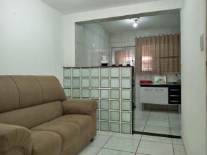 uma sala de estar com um sofá e uma cozinha em Um Paraíso no fim da rua em Barra de São Miguel