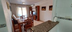 a kitchen and dining room with a table and chairs at Apartamento Angel Salamanca 38 in Santa Pola