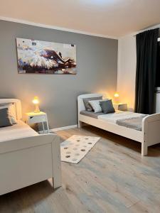 a bedroom with two beds and a painting on the wall at Apartman Luna *** in Rijeka