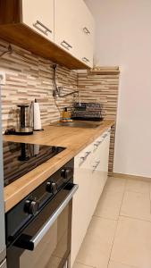 a kitchen with white cabinets and a stove top oven at Apartman Luna *** in Rijeka