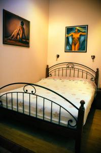 a bedroom with a bed with two pictures on the wall at Sunny Apartman in Szeged