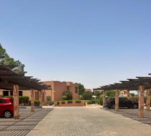 ein Parkplatz mit einem roten Auto, das darin geparkt ist in der Unterkunft Luminous apartment with pool view in Marrakesch