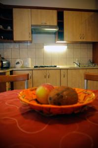 a plate of fruit on a table in a kitchen at Sunny Apartman in Szeged
