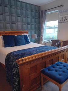 a bedroom with a large wooden bed with blue pillows at The Baytree Restaurant & Guesthouse in Carlingford