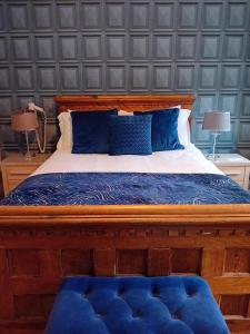 a bedroom with a large bed with blue pillows at The Baytree Restaurant & Guesthouse in Carlingford