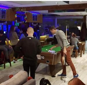 two men playing a game of pool in a casino at Marco Polo Party Hostel in St. Julianʼs
