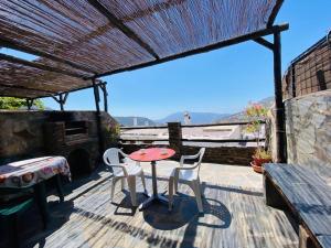 a patio with a table and chairs on a deck at Muley Hacén in Capileira