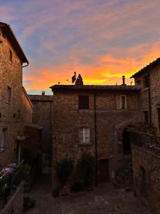 een persoon op het dak van een gebouw bij zonsondergang bij 81Passi in Casale Marittimo +15 foto's