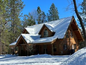 a log cabin with snow on the roof at Shasta Lake Luxury Log Cabin: Hot tub & Pool in Lakeshore