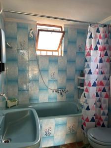 a bathroom with a tub and a toilet and a window at O'GERA Greek resort house in the mountains in Kókla