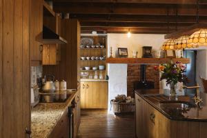 a kitchen with wooden cabinets and a counter top at Maggie Deenys Cottage 