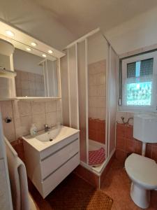 a bathroom with a sink and a shower and a toilet at Jázmin Apartman Zalakaros in Zalakaros
