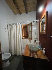 a bathroom with a glass sink and a mirror at Ruedas Negras Casa de Campo in Los Árboles