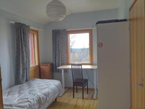 a bedroom with a bed and a desk and a window at Kiisa A and B with aurora rooms in Saariselka