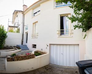 uma casa branca com uma garagem branca em Résidence Hera Paris Orly Aéroport em Villeneuve-le-Roi