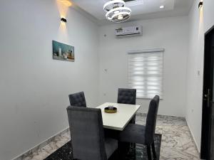 ein Esszimmer mit einem weißen Tisch und Stühlen in der Unterkunft KAIR Service Apartments in Benin-Stadt
