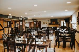 uma sala de jantar com mesas e cadeiras num restaurante em Hotel Spa San Marcos em Santillana del Mar