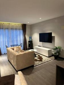 a living room with a couch and a flat screen tv at Cosy Home in Westlands in Nairobi