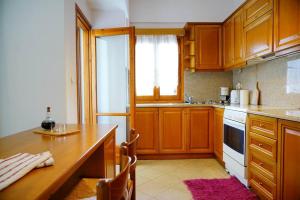 a kitchen with wooden cabinets and a wooden table at Friends and Family in Sisi