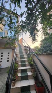 un escalier avec des plantes en pot sur le côté d'une maison dans l'établissement Karanxha's room, à Tirana