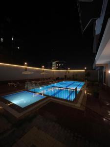 uma piscina à noite com luzes num edifício em Holiday 7 Kestel em Alanya