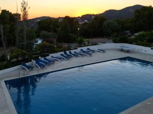 una piscina con sillas y una puesta de sol en el fondo en La calma de Tossa, en Girona