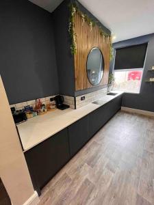 a bathroom with a sink and a mirror in a room at Modern 5 Bedroom Terraced Luxurious House in Colwyn Bay