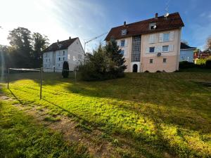 a house on a field with a fence in front of it at Ferienwohnung Laufenburg in Laufenburg