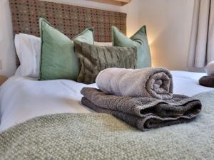 ein Bett mit einem Haufen Handtücher drauf in der Unterkunft Red Tub Cabin Snowdonia in Llanrwst