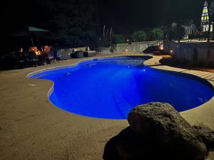 a large blue swimming pool at night at Shasta Lake Luxury Log Cabin: Hot tub & Pool in Lakeshore