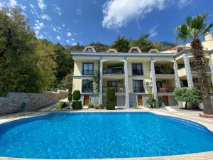 a villa with a swimming pool in front of a building at Mavi Ev in Marmaris