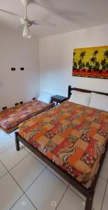 um quarto com uma cama com um cobertor colorido em Apto Ubatuba Home - Eloisa 114 em Ubatuba