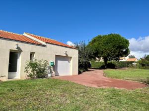 a driveway leading to a house with a tree at Villa Bleu soleil in Pornic