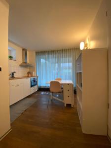 a kitchen with a table and a chair in a room at Chaleureux studio entre Neuchatel et Bienne in Le Landeron