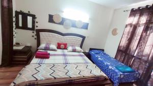 a bedroom with a bed with a blue comforter at Exclusive Floor on Manali Expressway for Family in Mohali