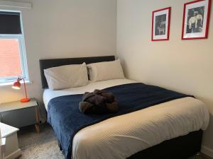 ein Schlafzimmer mit einem Bett mit einem ausgestopften Tier darauf in der Unterkunft Cannock - 2 large bedroom house for work & leisure in Great Wyrley