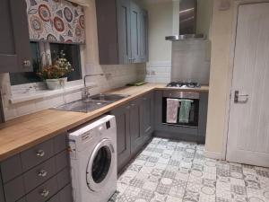 a kitchen with a washing machine in the middle at Single room Beeston wollaton park near University in Nottingham