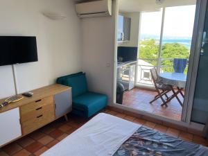 Zimmer mit einem Schreibtisch, einem Stuhl und einem Fenster in der Unterkunft Appartement piscine et vue mer in Tartane