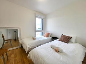 a bedroom with two beds with dolls on them at Le Lucie - Bain de lumière au pied du métro in Bagneux