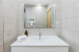 een witte badkamer met een wastafel en een spiegel bij Blue Apartments in Leiria