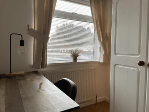 a room with a table and a window with a window blind at Dinizia, 2 bedrooms, sleeps 5 in Birmingham