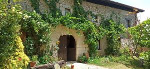 a stone house with an archway in a yard at Casa Rural TTIPIAENEA Landetxea in Ariz +34 photos