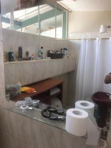 bagno con bancone in vetro e servizi igienici di departamento amoblado a Quito
