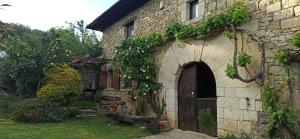 an old stone building with a door and a yard at Casa Rural TTIPIAENEA Landetxea in Ariz