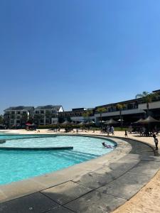 una piscina en una playa con gente en ella en The Blyde Crystal Lagoon Riverwalk Estate, en Pretoria