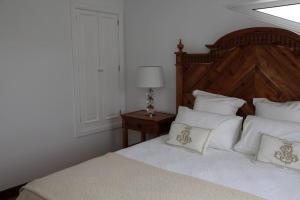 Ribeira das Tainhas的住宿－Quinta do Avô，一间卧室配有带白色床单和枕头的床。