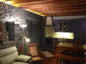 a living room with a stone wall and a table at Quinta do Avô in Ribeira das Tainhas